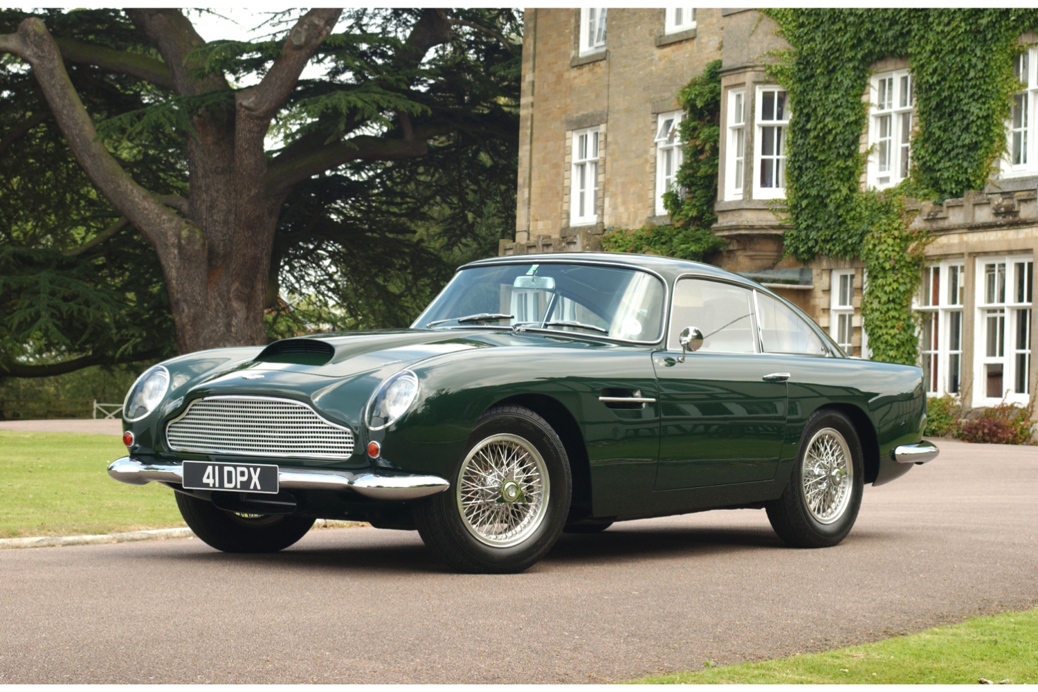 1959__1963_DB4_GT_2 Image of green classic Aston Martin DB4 parked in front of large stately home